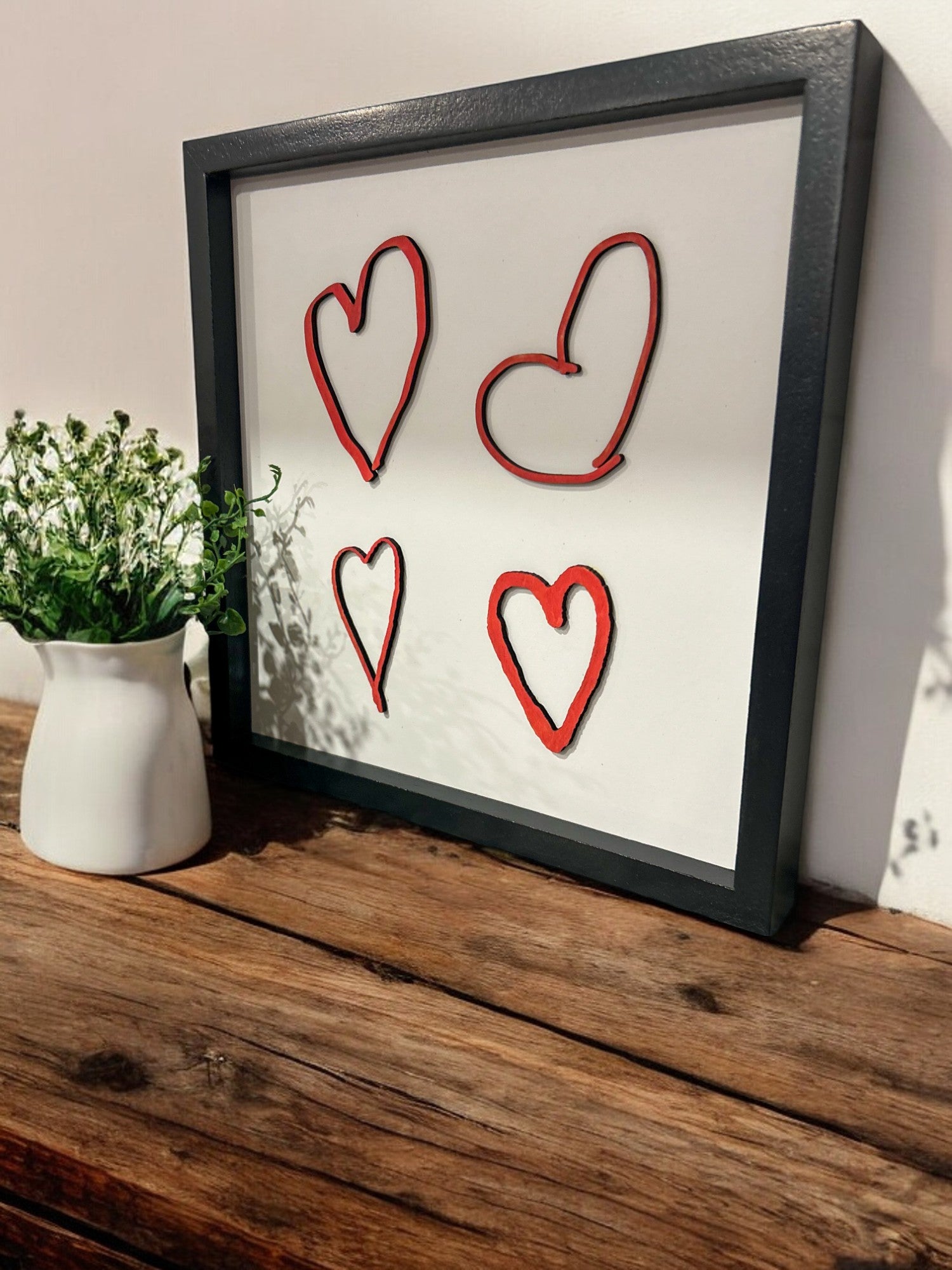 Capturing the essence of love and connection, a photo featuring a trio of beautifully crafted handwritten hearts on a sign. 